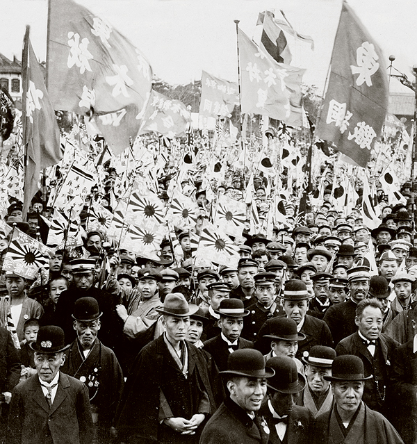 This 1905 photo of a flag-waving crowd in Tokyo records the mixed outcome of the Russo-Japanese War. Smiles reflect Japan's supremacy over its Russian foe, while grim faces belie the high toll of that victory. (Library of Congress)