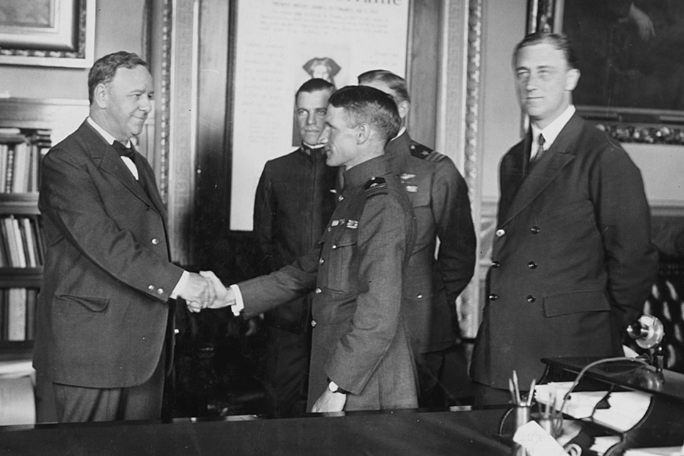 Navy Secretary Josephus Daniels congratulates (from left) NC-1’s commander Patrick N.L. Bellinger, NC-4’s Read and flight commander John H. Towers, while Assistant Secretary of the Navy Franklin D. Roosevelt looks on. (Naval History and Heritage Command)