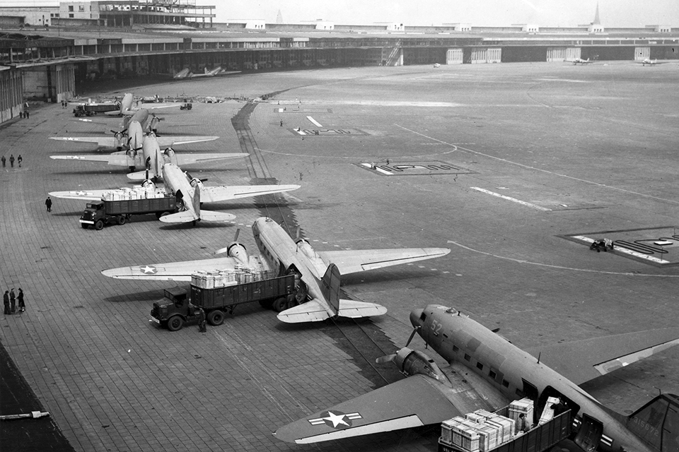 At Templehof, C-47 Skytrains unload their cargo as part of a round the clock airlift of desperately needed supplies. (National Archives)