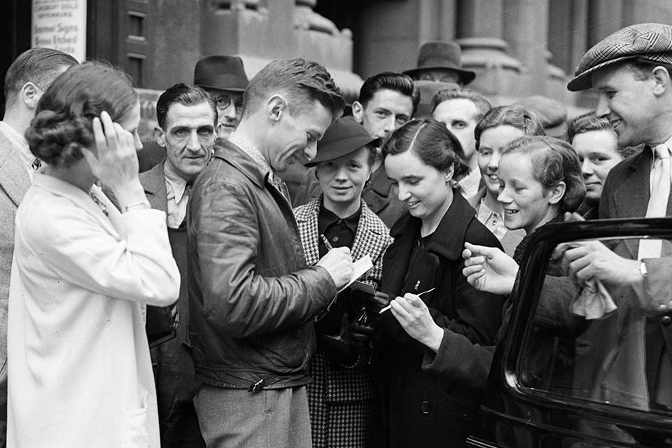 After being questioned by an Irish customs official—and more pointedly by U.S. Minister Stephen Cudahy—Corrigan signs autographs for fans in Dublin before departing for New York by ship. (Keystone/Getty Images)