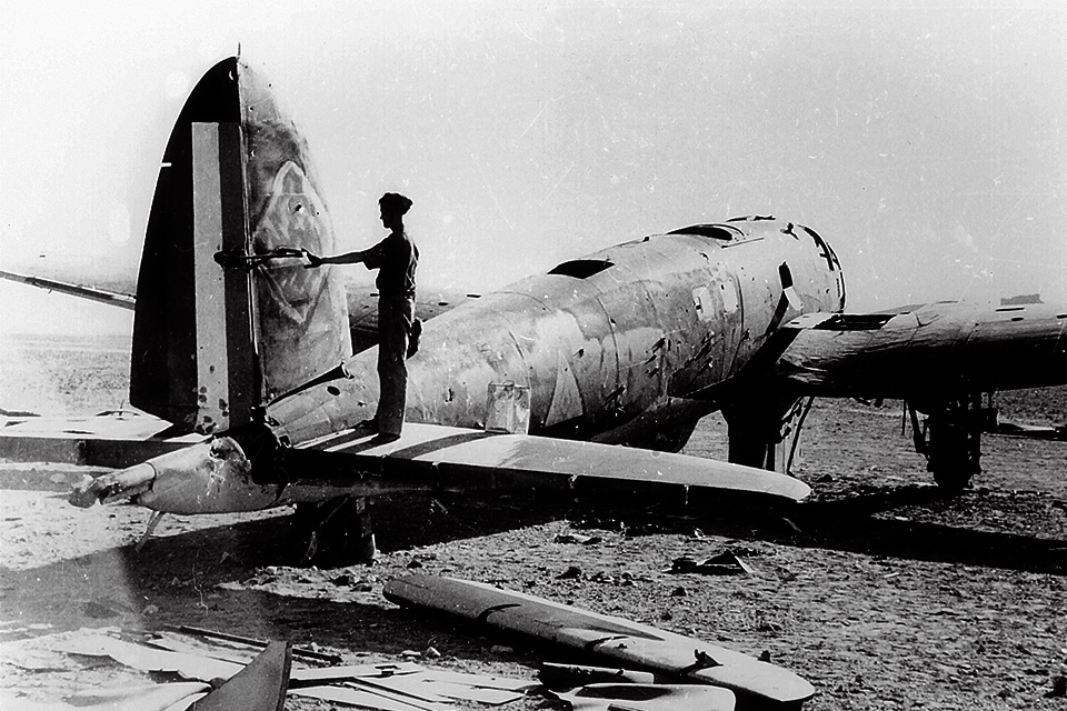 A British soldier examines an abandoned He-111H, one of a group of Luftwaffe aircraft sent to reinforce Rashid Ali's revolt. (Imperial War Museum)