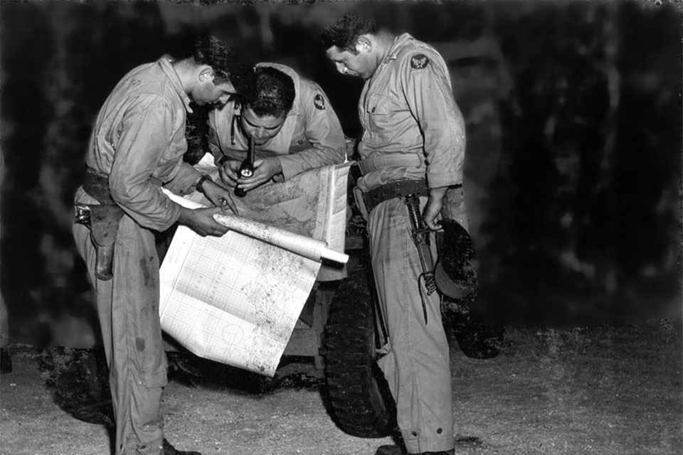 Capt. James Van Pelt, Maj. Charles Sweeney and Lt. Fred Olivi review their route prior to takeoff on the Nagasaki mission. (National Archives)