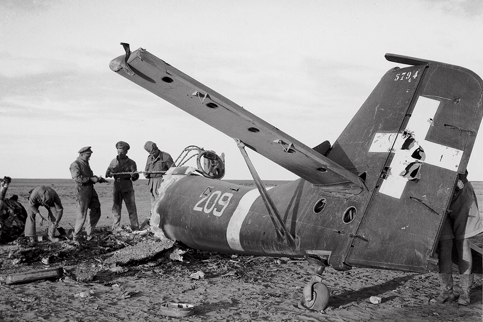 British airmen examine the wreckage of a Junkers Ju-87B in Italian markings, shot down by a Hurricane pilot on the Libyan battlefront.