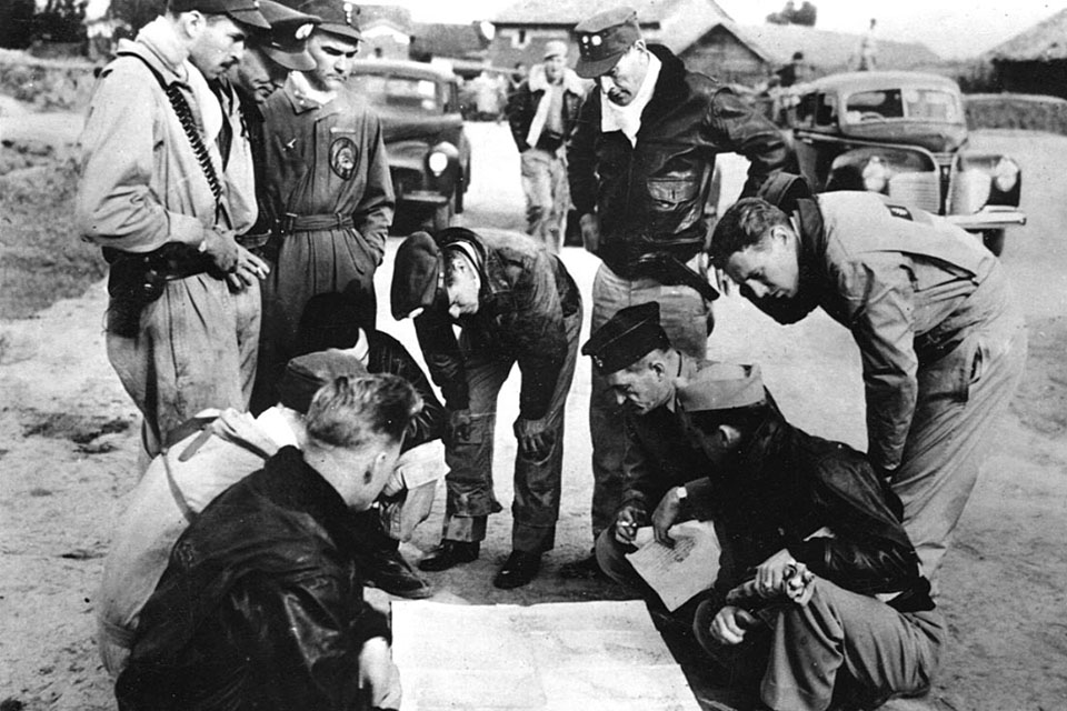 Chennault (kneeling, in dark hat) confers with AVG members over a map. The Flying Tigers’ primary role between December 1941 and July 1942 was to protect the Burma Road. (Flying Tiger Association)