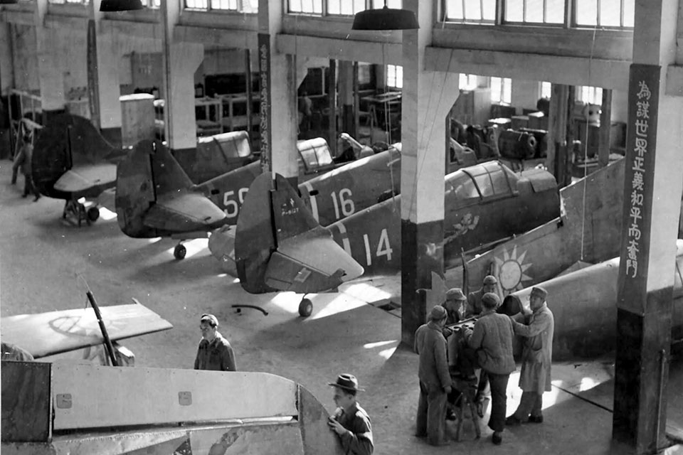 P-40s undergo maintainence at a CAMCO (Central Aircraft Manufacturing Company) depot. The workers are inspired by the words painted on the supports that read "Working for Righteousness and Peace." (National Archives)