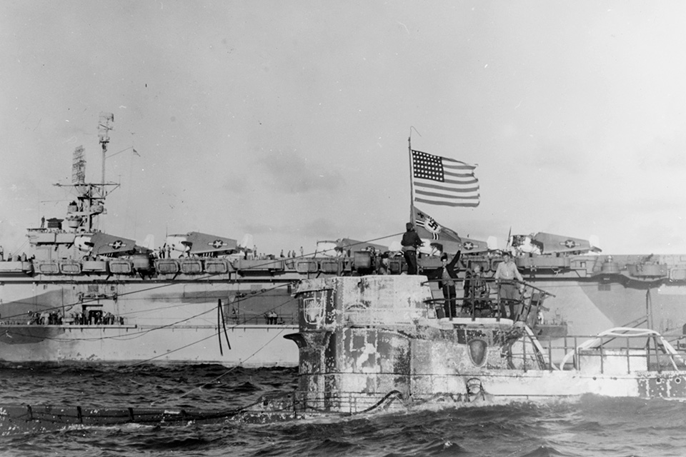 Having hoisted the stars and stripes over the Nazi naval ensign, Captain Daniel V. Gallery's boarding party keep U-505 afloat. In the background is the flagship of Task Group 22.3, the USS Guadalcanal. (National Archives)