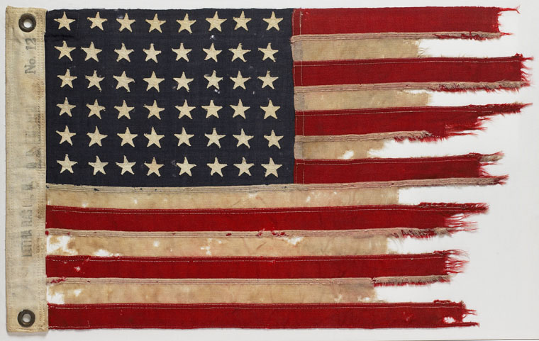Per original caption: United States flag from PT 109 motor torpedo boat, which flew on the vessel during Lieutenant John F. Kennedy's command in April-August of 1943. This flag was removed from PT 109 by Charles Harris, a crew member, in Tulagi Harbor when the boat was being overhauled in July, 1943. (John Fitzgerald Kennedy Library)