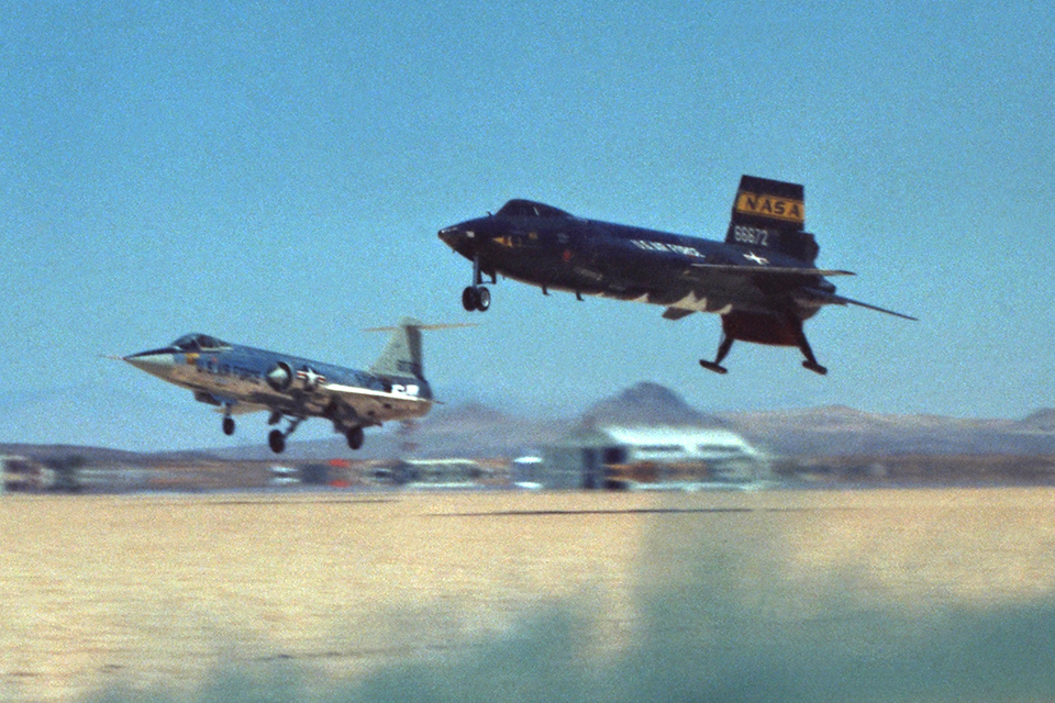 Followed by an F-104 chase plane, an X-15 returns to the dry lakebed at Edwards AFB in California. The X-15's combination of a traditional nose wheel and two rear landing skids was unique. (NASA)