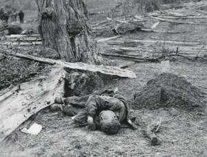 An unidentified Confederate, and the fresh grave of Lt. John A. Clark, 7th Michigan, lie near the West Woods in this photograph commissioned by famed Civil War photographer Mathew Brady.