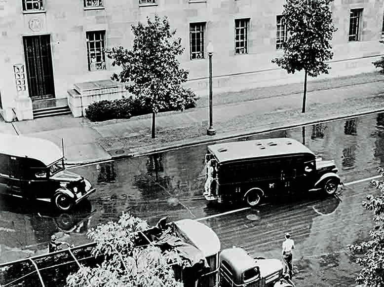 A bystander watches trucks carrying the prisoners form the Justice Department. (National Archives)