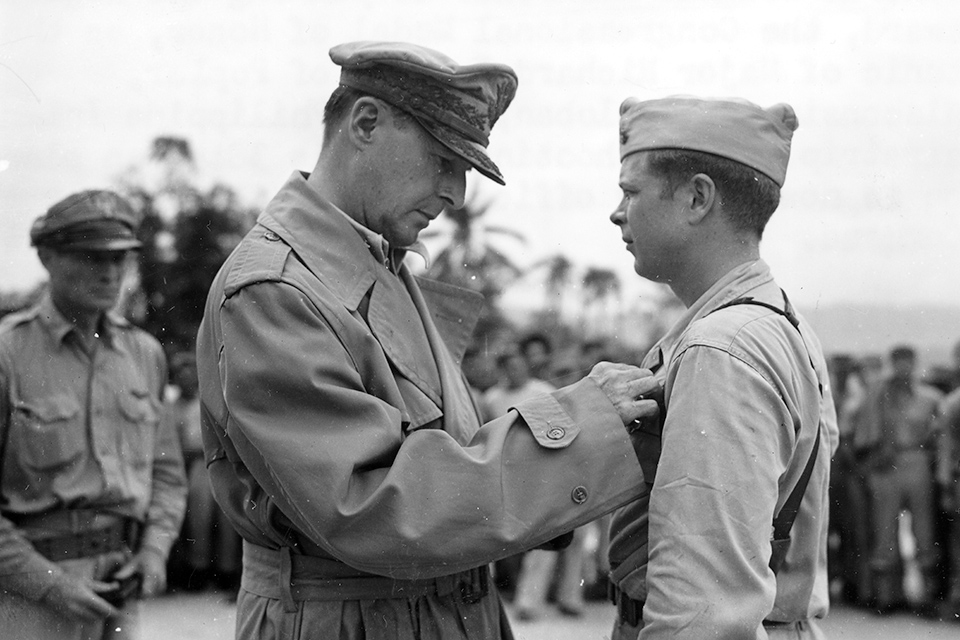 General Douglas MacArthur presents the Medal of Honor to Bong in December 1944. After the ace scored two more victories on December 15 and 17, bringing his total to 40, General George C. Kenney ordered him home for the last time. (National Archives)