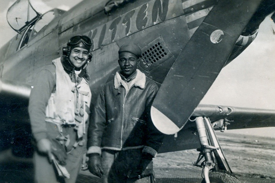 At Ramitelli airfield in Italy, McGee stands in front of the P-51C Mustang he named "Kitten" for his wife. At his side is Nathaniel Wilson, the Mustang's crew chief.