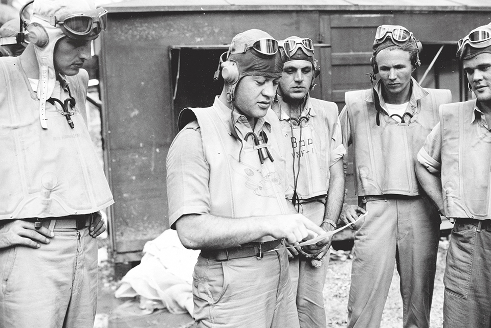 Beneath the palms at Turtle Bay, Boyington briefs (from left) Rollie Rinabarger, Hank “Boo” Bourgeois, John Begert and Stan Bailey. (National Archives)