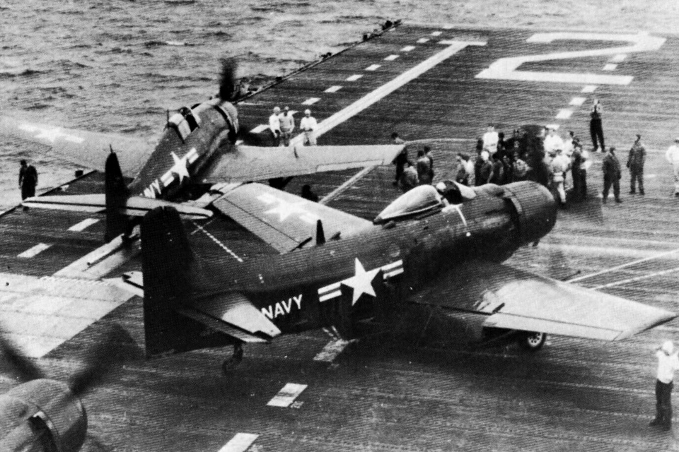 An F6F-5K drone and its Douglas AD-2Q Skyraider controller aircraft move into position on the carrier USS Boxer off the coast of Korea in August 1952. (U.S. Navy)