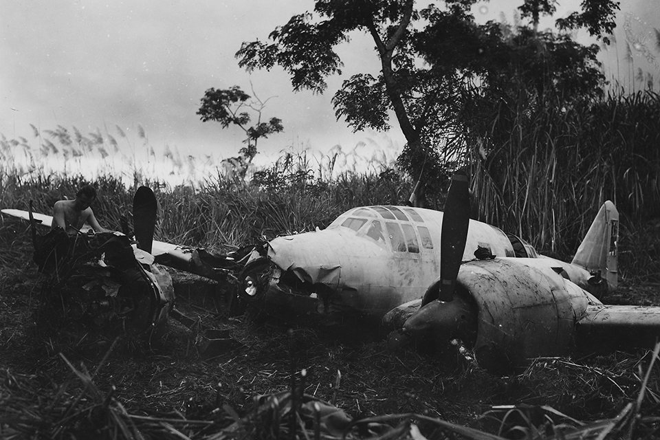 A member of the Technical Air Intelligence Unit examines a relatively intact Mitsubishi Ki.46 Dinah reconnaissance plane discovered in New Guinea. (Courtesy of Linda Grow)
