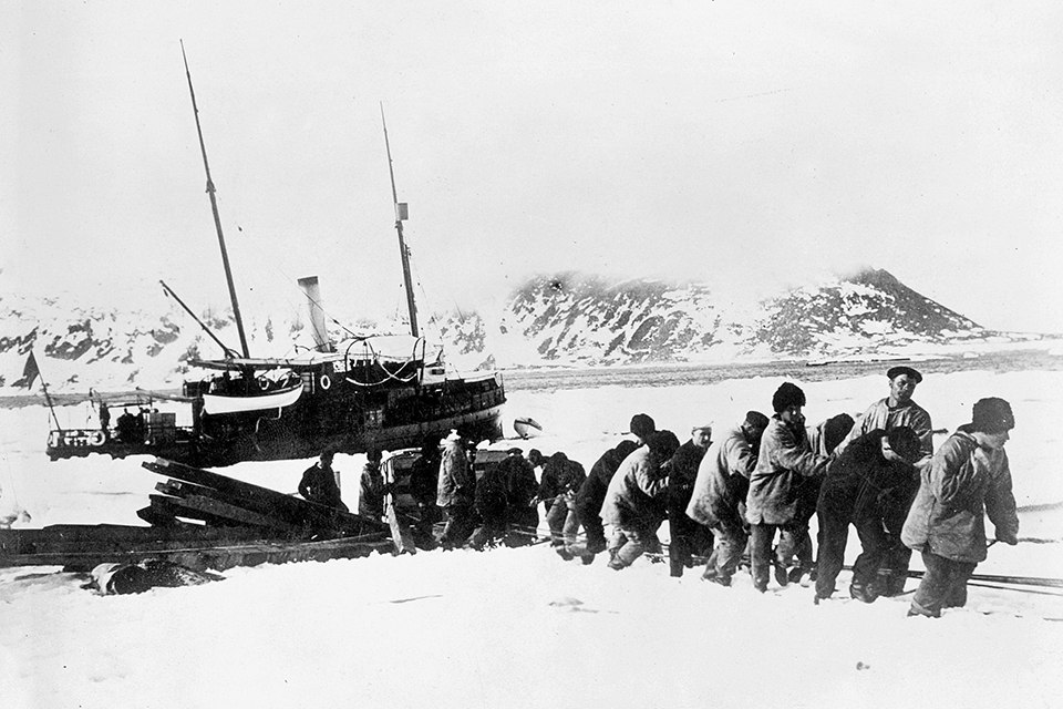 Virgo’s crewmen drag equipment ashore on Danes Island, which served as the polar expedition’s base of operations. (Sueddeutsche Zeitung Photo/Alamy)