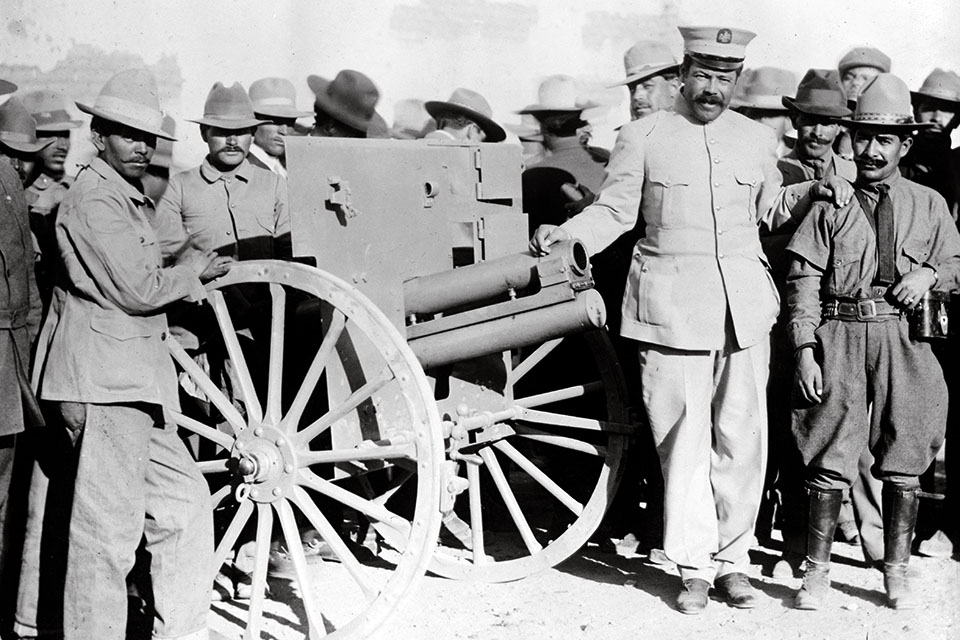 Pancho Villa (to right of the cannon) poses in a uniform supplied by Mutual Films in 1914. (Library of Congress)