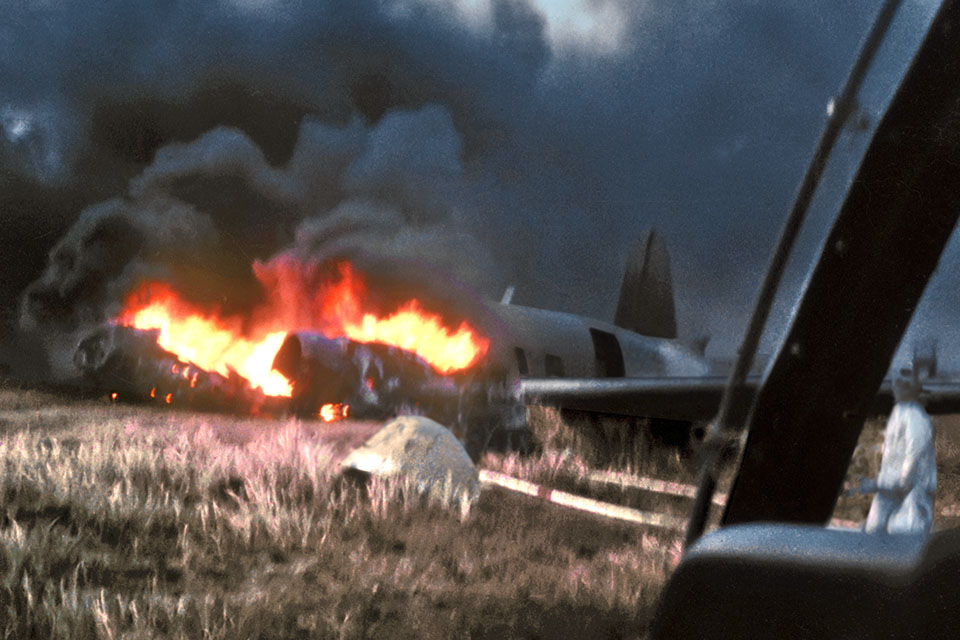 The AC-47 burns at Bien Hoa on March 23, 1967, after losing an engine to sniper fire during takeoff. (Chuck Boatwright via Steve Birdsall)