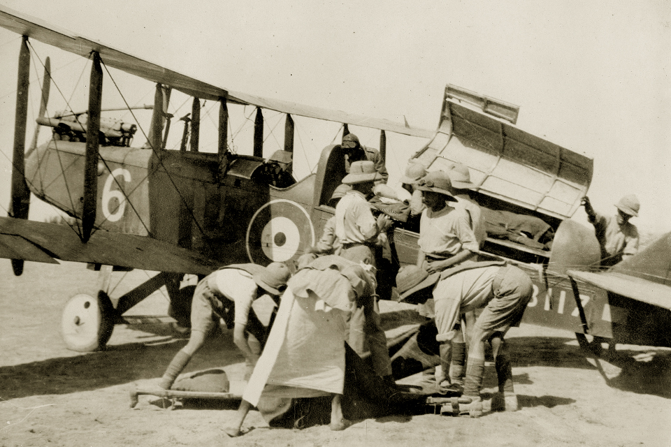 RAF personnel and a member of the Somaliland Field Force load a casualty aboard a D.H.9, modified into an aerial ambulance, for evacuation to the port city of Berbera. (RAF Museum, Hendon)