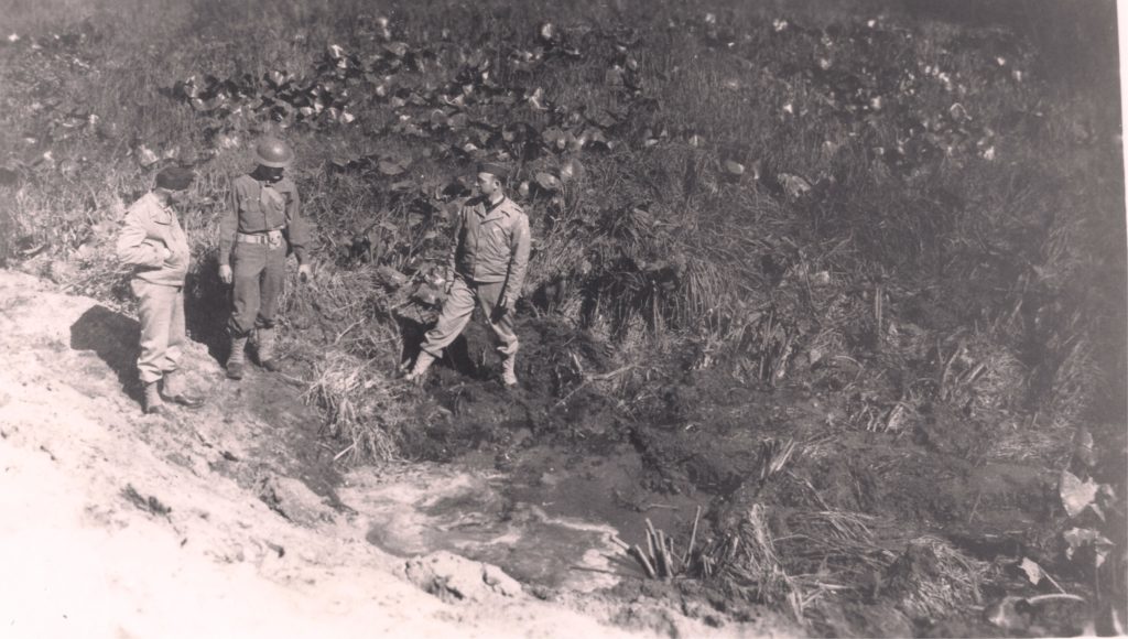 Soldiers from Fort Stevens, Oregon, inspect a five-foot crater created by a shell fired from a Japanese submarine. (Fort Stevens State Park)