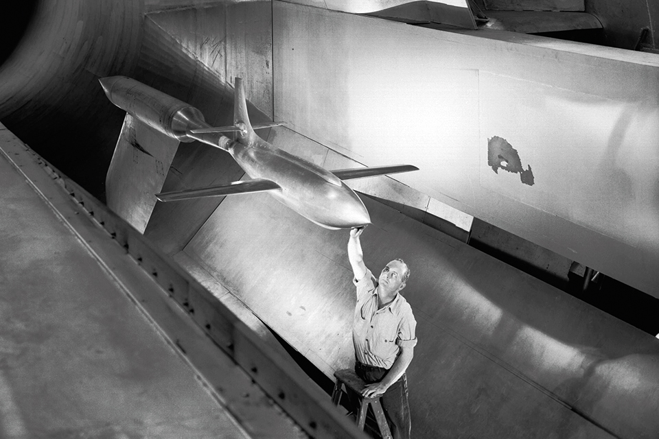 A researcher positions a model of the XS-1 inside the 16-foot high-speed wind tunnel at Langley Research Center in Virginia. (NASA)