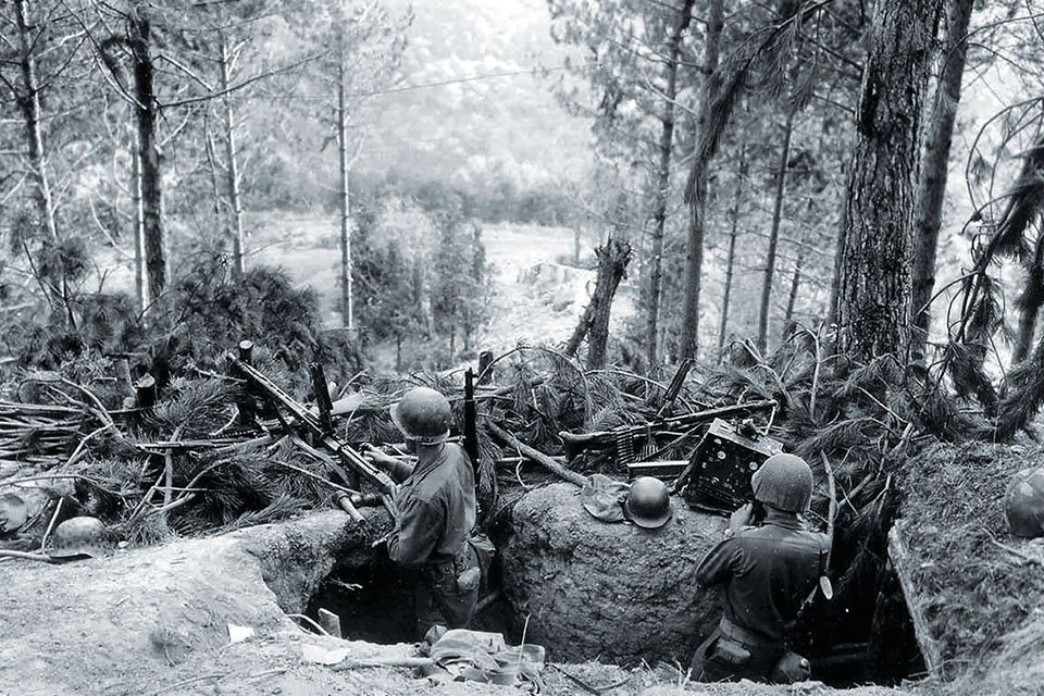 American soldiers examine weapons and gear abandoned by retreating Germans. (US Army Signal Corps)