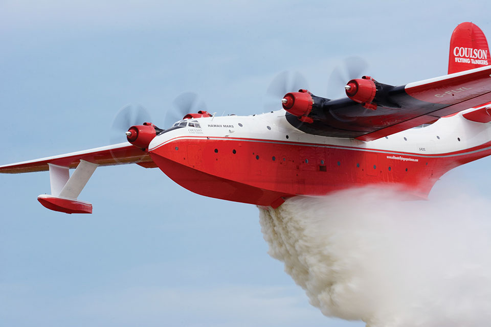 Coulson Flying Tankers’ Hawaii Mars makes a demonstration drop at EAA Airventure in 2016. The giant flying boat can scoop up 7,200 gallons of water in just 25 seconds. (Mike Collins/AOPA)
