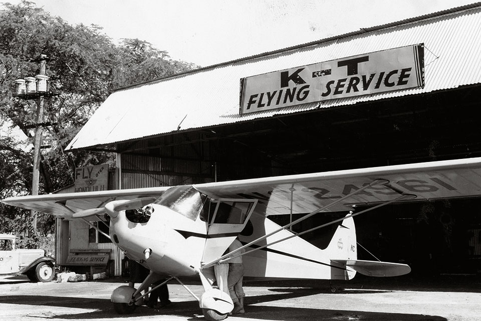 K-T Flying Service's Piper J4A Cub Coupe stands in front of the firm's Honolulu hanger. (Courtesy of Dr. Robert C. Tyce)