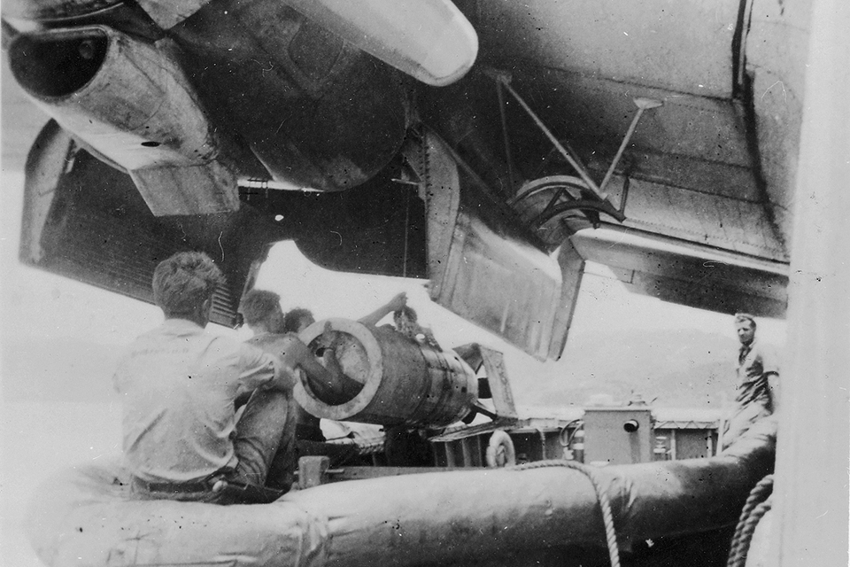 Members of "Dinah Might’s" crew use a winch to lift a top-secret Fido acoustically guided torpedo into the PBM’s bomb bay. (Courtesy of Jack Christopher)