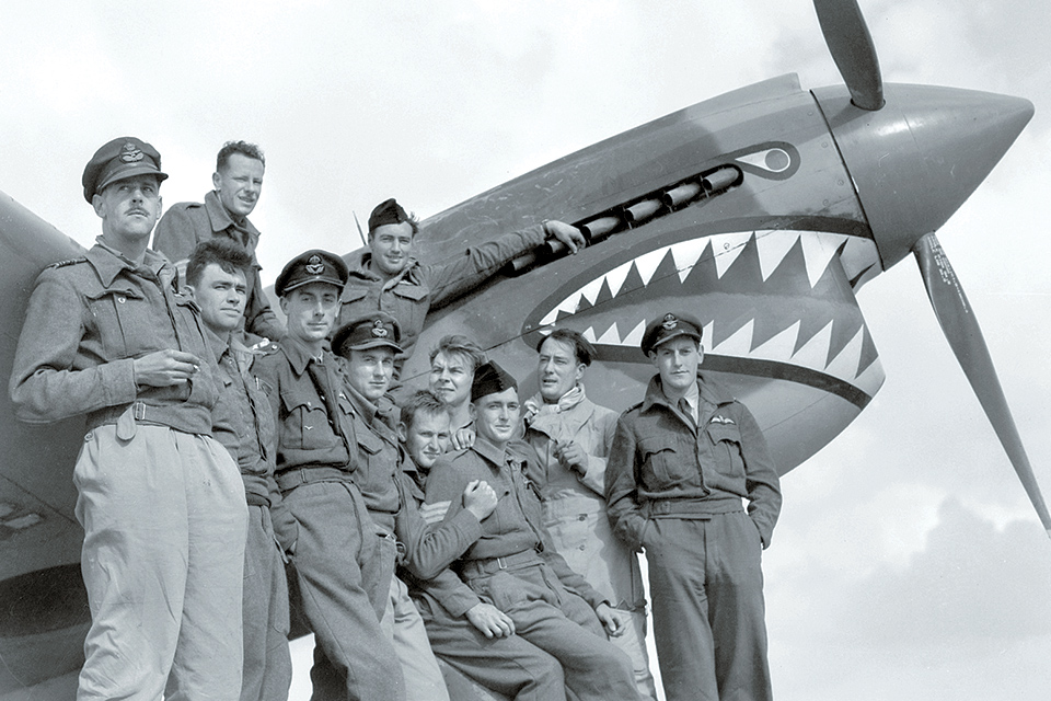 Caldwell (far left) and members of No. 112 Squadron pose beside one of the unit’s shark-mouth Kittyhawks in January 1942. (AWM 011944)