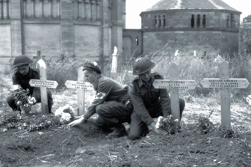 Members of the Royal Canadian Army Medical Corps tend the graves of soldiers and civilians killed by German forces in Basly, Normandy. (Galerie Bilderwelt/Getty Images)