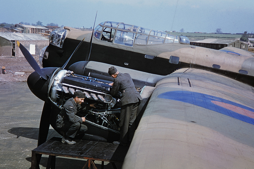 Mechanics work on one of four Merlins powering an Avro Lancaster bomber of No. 207 Squadron at RAF Bottesford airfield, Lincolnshire, in June 1942. (IWM TR 0020)