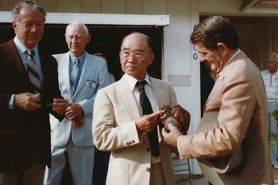 Sakai shows his bullet-holed flying helmet to Harold Jones, the SBD-3 gunner who almost shot him down in August 1942. (Courtesy of Henry Sakaida)