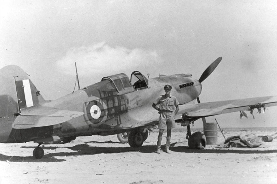 Caldwell stands with the Curtiss P-40 Tomahawk that brought him home after an intense dogfight on August 29, 1941. The rugged P-40 absorbed everything the attacking Messerschmitt Me-109s could dish out, leaving Caldwell with just a few cuts and scratches. (AWM P0344)