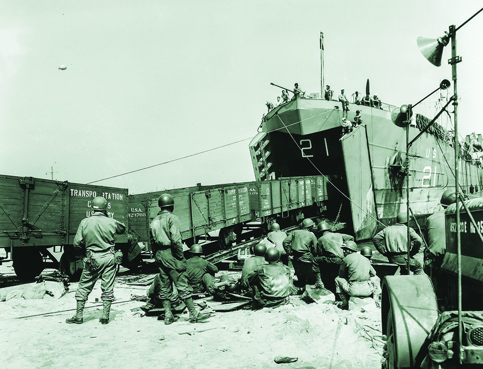 LSTs—like these in England, being loaded with railroad cars destined for Normandy—were a vital component of landings in all corners of the world. (U.S. Coast Guard/National Archives)