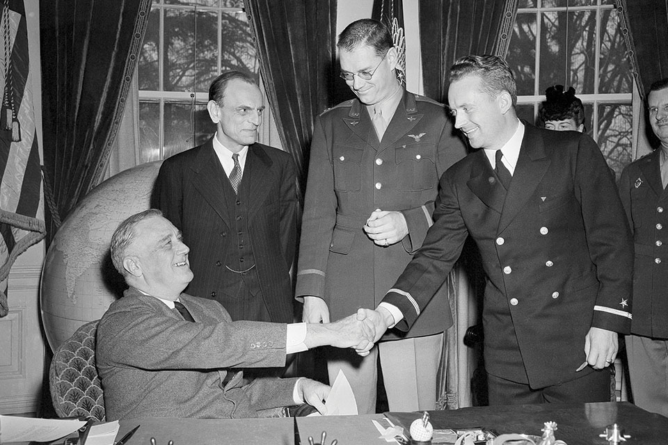 President Franklin D. Roosevelt awards Air Medals to CAP crewmen Edmond Edwards (right) and Hugh Sharp (middle) while Director of Civilian Defense John Landis looks on. (AP Photo/George R. Skadding)