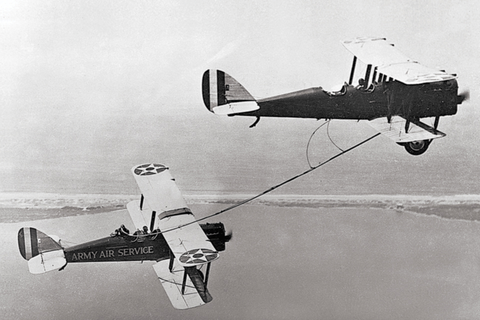 Captain Lowell Smith and 1st Lt. John Paul Richter refuel their Liberty DH-4B on their way to a record nonstop flight of more than 37 hours in August 1923. (U.S. Air Force)