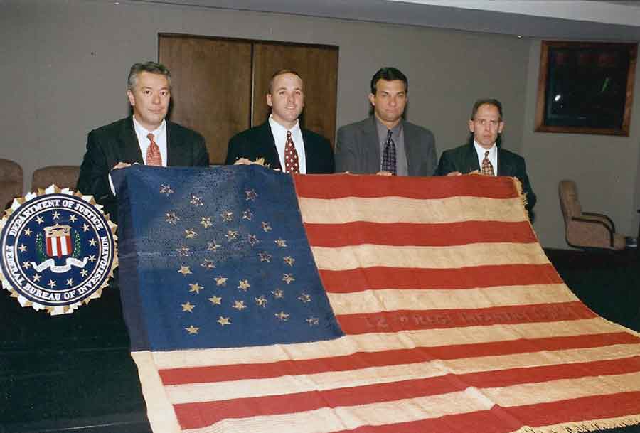 Monumental Save: Bob Wittman (left) and his team of investigators display the 12th Regiment Corps d’Afrique battle flag they repossessed during a carefully planned sting. (Courtesy of Robert Wittman)
