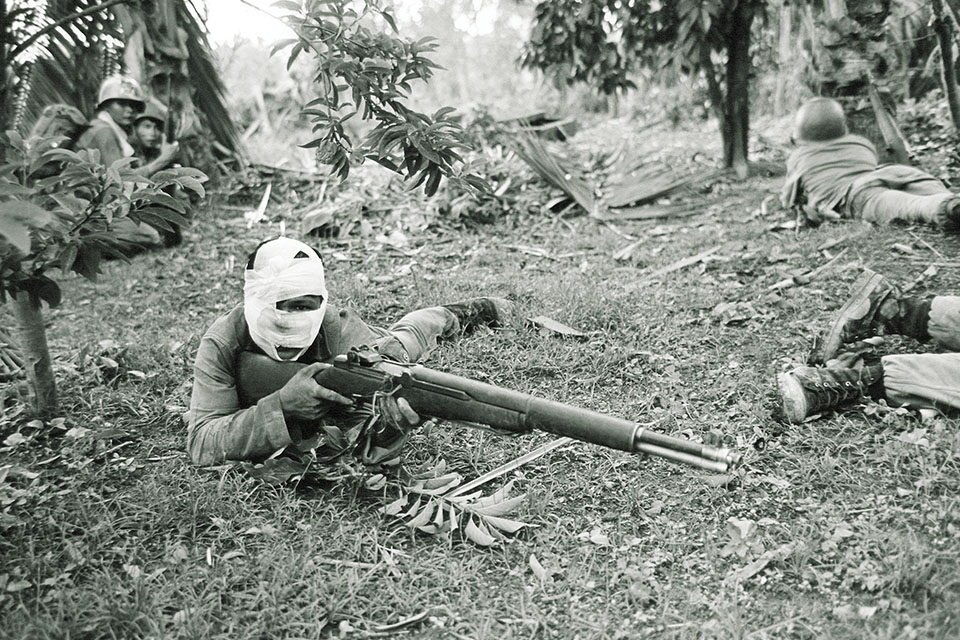 A wounded South Vietnamese ranger takes aim at the Viet Cong on June 11. (AP Photo/Hosrt Faas)