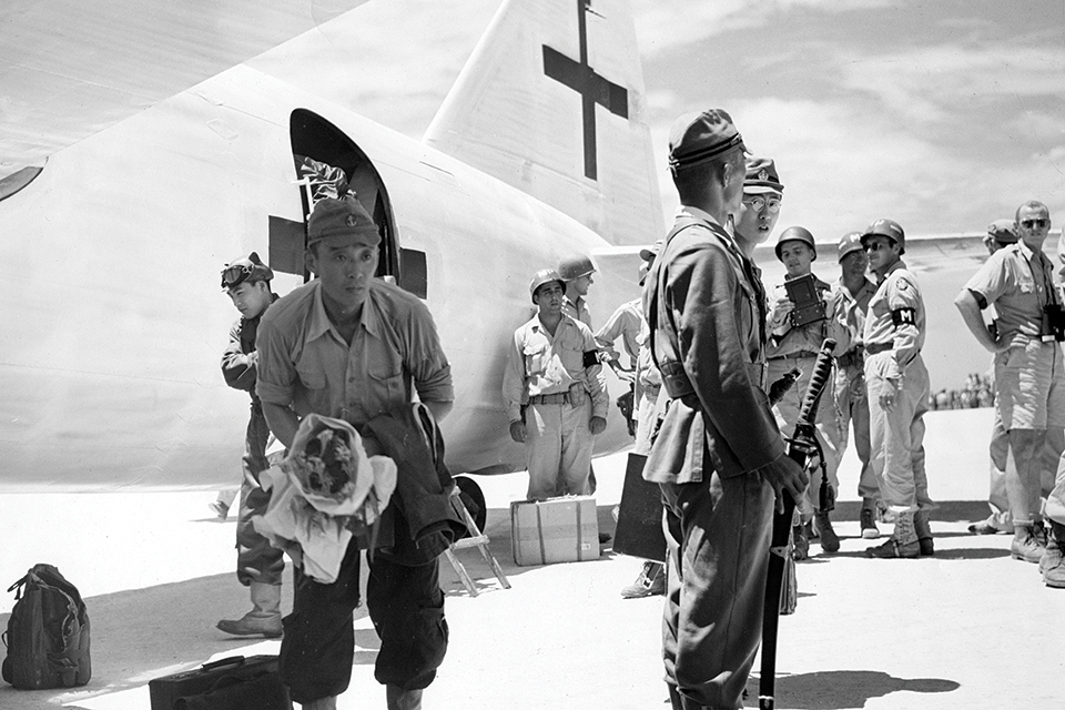 Members of the Japanese delegation debark from their aircraft and prepare to board a C-54 for a flight to Manila, where they will receive instructions concerning the surrender and American occupation. (U.S. Navy)