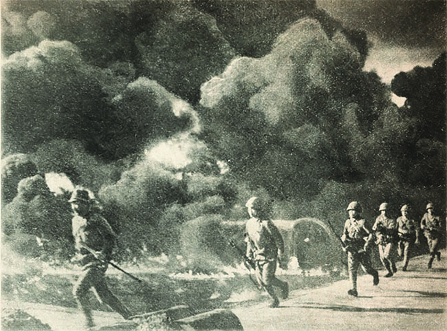 In 1942, Japanese soldiers storm through Philippine oil fields set ablaze by retreating American troops. (Getty Images)
