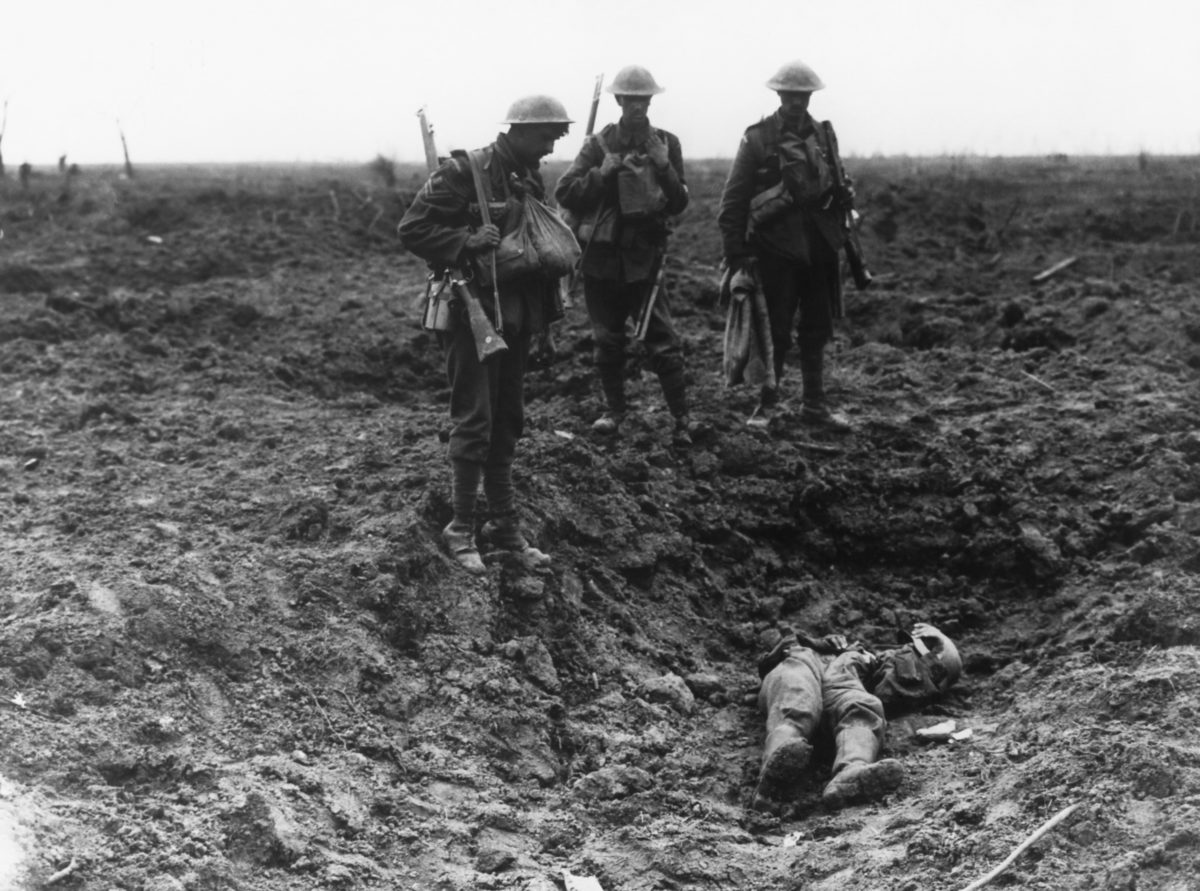 British Soldiers Stand Over Dead German In a Shell Crater