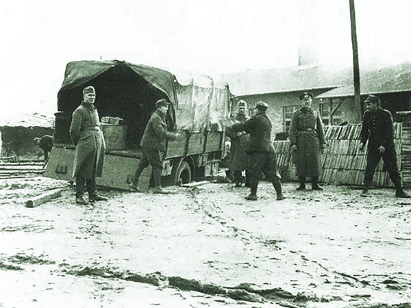 Under their guards’ watch, prisoners at Stalag III-A (top) unload a truck. (Stalag3a.com) 