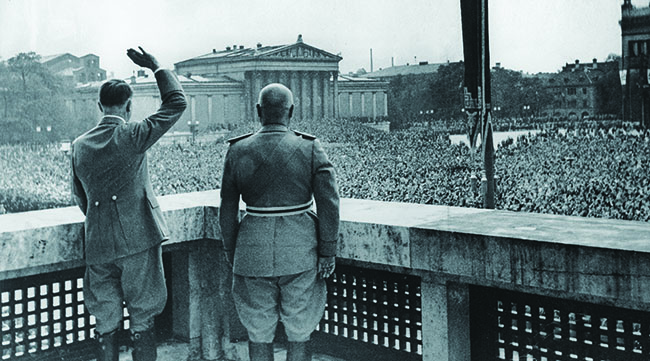 Adolf Hitler and Benito Mussolini embrace the pageantry of politics, greeting a cheering square in Munich, Germany, in 1937. (Ullstein Bild via Getty Images)