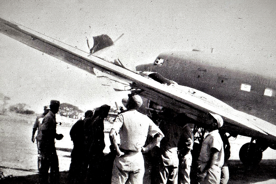 Crewmen inspect flak damage to the 317th Troop Carrier Group C-47 ”Jungle Skipper” upon its return from dropping paratroopers over Corregidor Island on February 16, 1945. (U.S. Air Force)