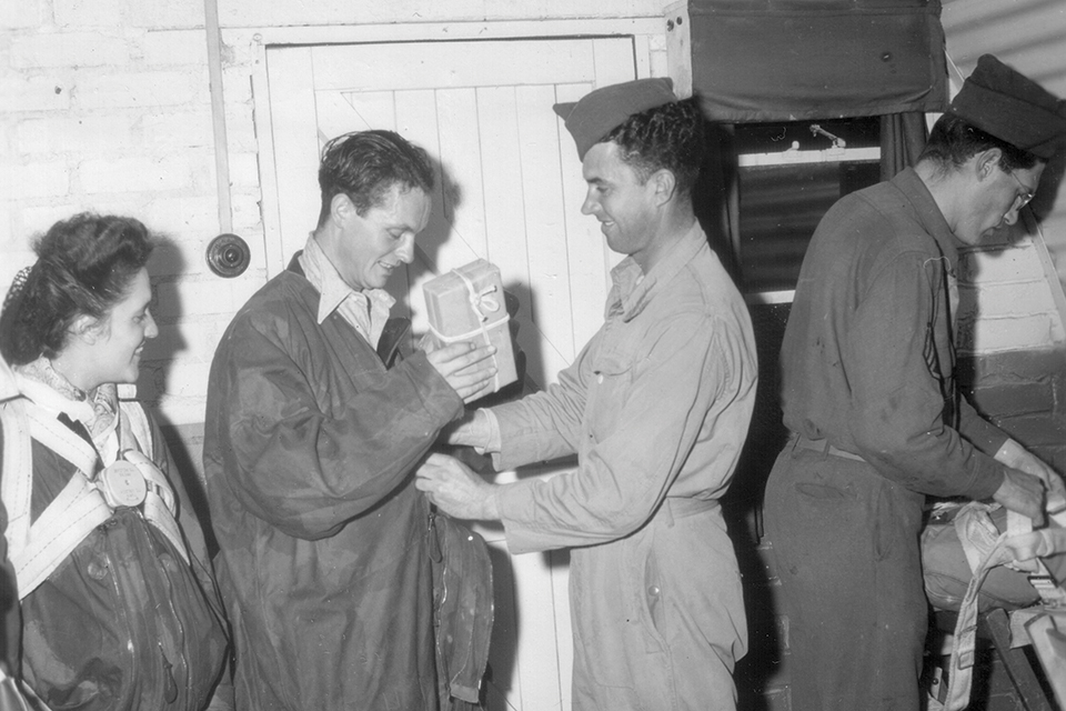 An OSS agent stows a package of French currency prior to parachuting into enemy territory. (National Archives)