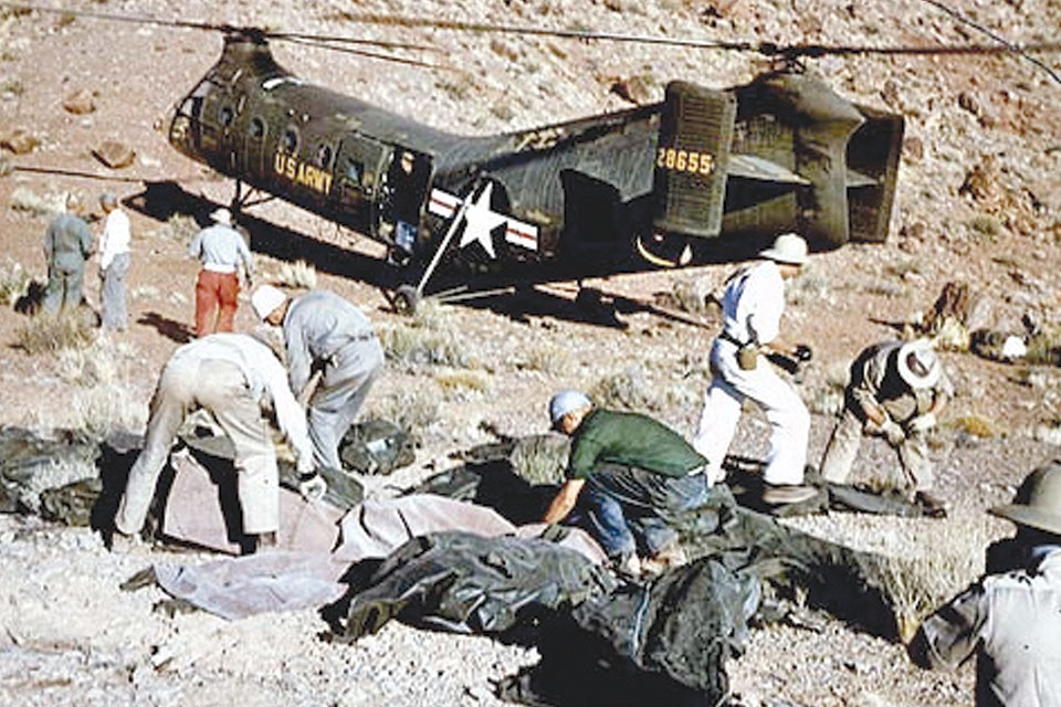 Transported to the TWA crash site by a U.S. Army Piasecki H-21 helicopter, a search team sorts through a scattered debris field, surrounded by a growing number of body bags. (National Park Service)