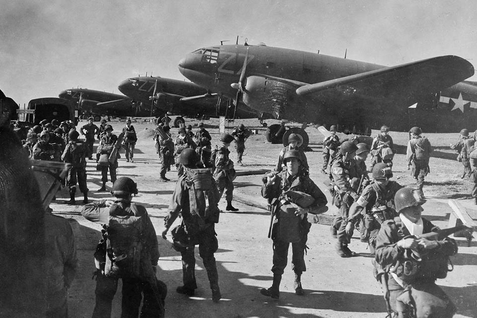Paratroopers of the 17th Airborne Division get ready to board their new Douglas C-46 planes of the 52nd Troop Carrier Wing for Operation Varsity, March 24, 1945. (National Archives).