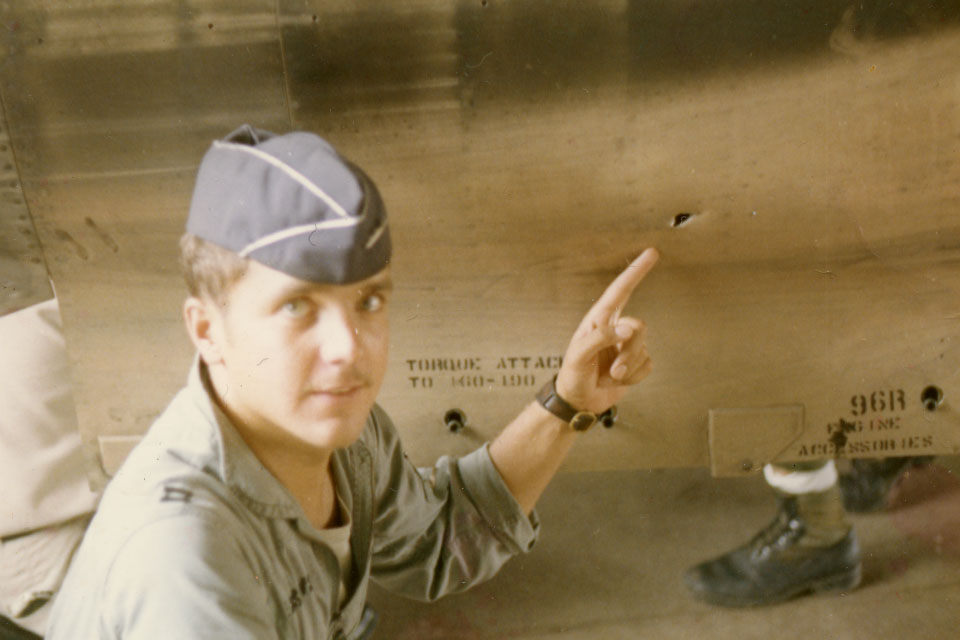 Captain Rudi Peksens points to shrapnel damage on his RF-4C in September 1970. (Courtesy Brig. Gen. Rudi Peksens)