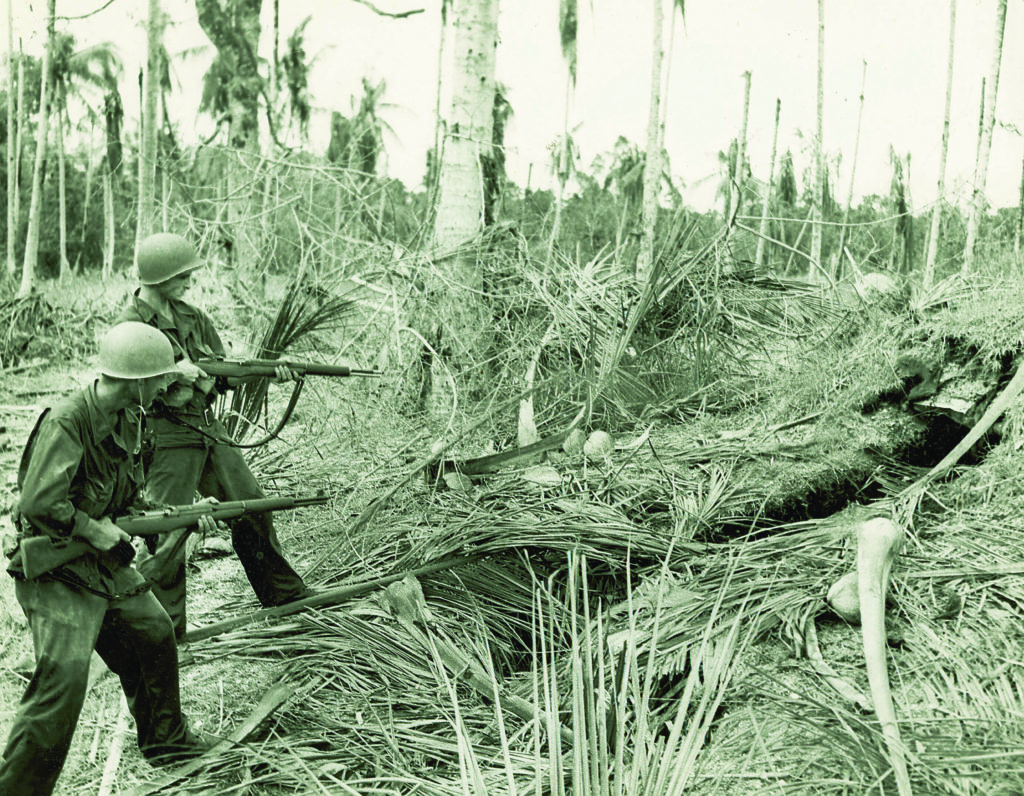 GIs approach a Japanese foxhole in Buna. Fire from such well-camouflaged hiding places and from snipers high in coconut trees was a deadly challenge to the Allied effort to oust the Japanese from the region. (U.S. Army Center of Military History) 